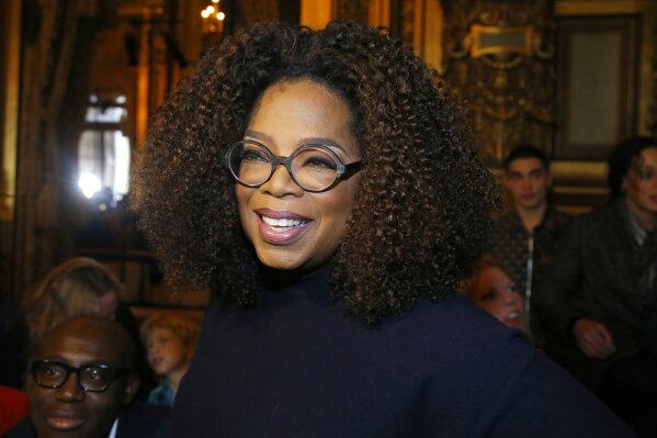 FILE - Oprah Winfrey arrives for the presentation of Stella McCartney's ready-to-wear Fall-Winter 2019-2020 fashion collection in Paris on March 4, 2019. Winfrey is setting aside her usual book club recommendations and instead citing seven personal favorites ranging from James Baldwin’s landmark essays in “The Fire Next Time” to Mary Oliver’s poetry collection “Devotions.” She is calling her choices “The Books That See Me Through,” works she values for “their ability to comfort, inspire, and enlighten” her. (AP Photo/Michel Euler, File)