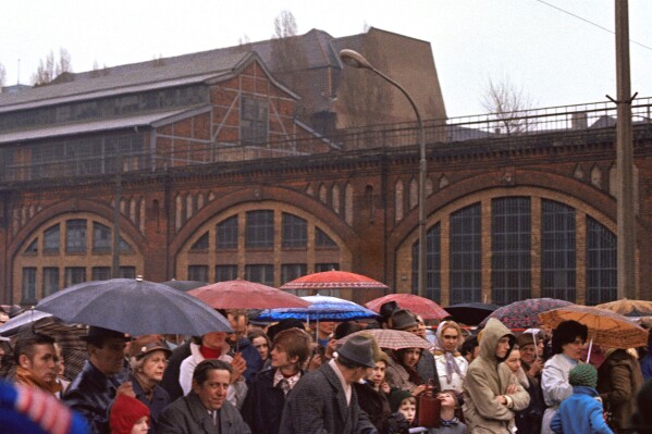 FILE - People queue at the Friedrichstrasss border checkpoint on March 31, 1972 to allow East and West Berlin residents to reunite. Prosecutors say a former member of communist East Germany’s secret police has been charged with murder over the killing of a Polish national at a border crossing in divided Berlin in 1974. (AP Photo/Dieter Endlicher, File)