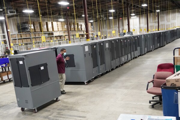 A worker returns voting machines to storage at the Fulton County Election preparation Center Nov. 4, 2020, in Atlanta. (AP Photo/John Bazemore, File)