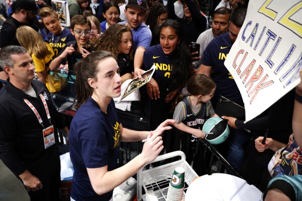 Indiana Fever guard Caitlin Clark signs autographs for fans before the start of WNBA basketball game against the New York Liberty, Saturday, May 18, 2024, in New York. (AP Photo/Noah K. Murray)