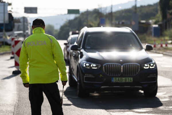 Police officers checks cars and vans at the Slovak-Hungarian border in Sahy, Slovenia, Thursday, Oct. 5, 2023. Slovakia began conducting border checks with neighboring Hungary on Thursday amid what it says is a dramatic rise in illegal border crossings, part of a flurry of similar border measures other Central European countries have imposed in recent days. (AP Photo/Denes Erdos)