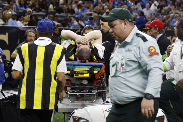 A member of the chain crew is wheeled off during the first half of an NFL football game between the New Orleans Saints and the Detroit Lions, Sunday, Dec. 3, 2023, in New Orleans. (AP Photo/Butch Dill)