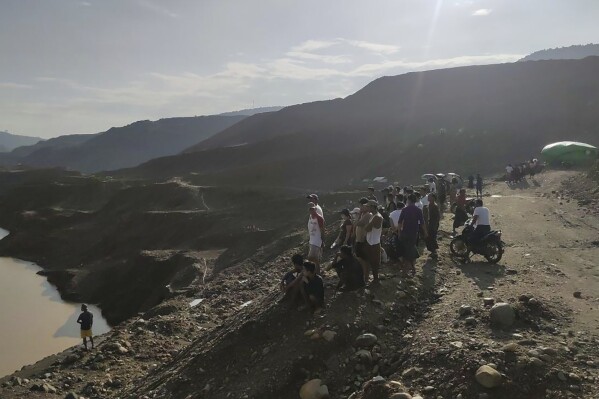 Miners, rescuers and local residents look at the jade mine site where a landslide accident took place in Hpakant township, Kachin state, Myanmar Sunday, Aug. 13, 2023. A landslide at the jade mine left scores of people missing, and a search and rescue operation was underway on Monday, a rescue official said. (AP Photo)