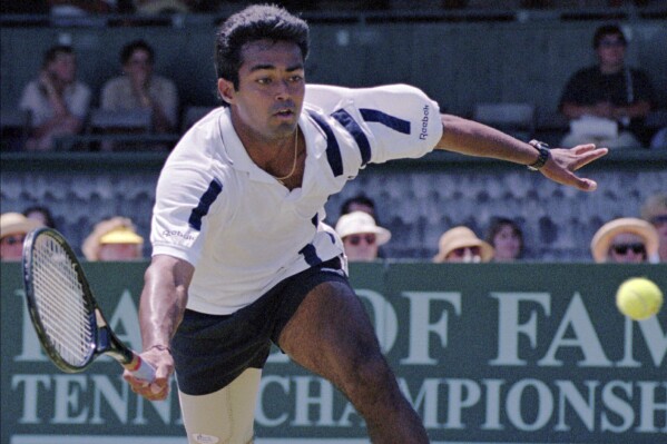 FILE - Leander Paes, of India, tries to maintain his balance while charging the ball during the quarterfinals of the Hall of Fame Tennis Championships in Newport, R.I., Thursday, July 10, 1997. Paes, who won 18 Grand Slam titles in men’s doubles or mixed doubles, and Vijay Amritraj are the first Asian men elected to the International Tennis Hall of Fame. The Hall announced its Class of 2024 on Wednesday., Dec. 13, 2023. (AP Photo/Matt York, File)