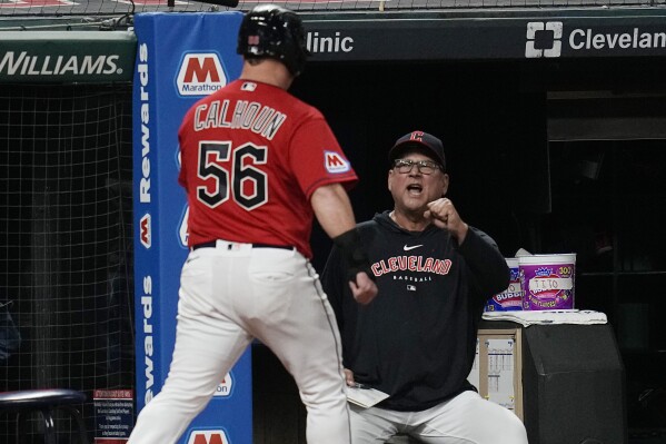 Cleveland Guardians manager Terry Francona, right, greets Kole Calhoun (56), who returns to the dugout after scoring against the Detroit Tigers during the eighth inning in the second baseball game of a doubleheader Friday, Aug. 18, 2023, in Cleveland. (AP Photo/Sue Ogrocki)
