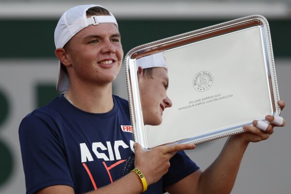 Switzerland's Dominic Stephan Stricker holds the trophy after winning the junior men's final match of the French Open tennis tournament against Switzerland's Leandro Riedi at the Roland Garros stadium in Paris, France, Saturday, Oct. 10, 2020. (AP Photo/Alessandra Tarantino)