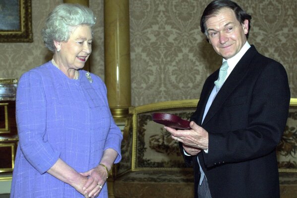 FILE - In this July 25, 2000 file photo, Britain's Queen Elizabeth II awards Roger Penrose with the Insignia of a Member of the Order of Merit at Buckingham Palace in London. The 2020 Nobel Prize for physics has been awarded to Briton Roger Penrose, German Reinhard Genzel and American Andrea Ghez for discoveries relating to black holes. (Fiona Hanson/PA via AP)