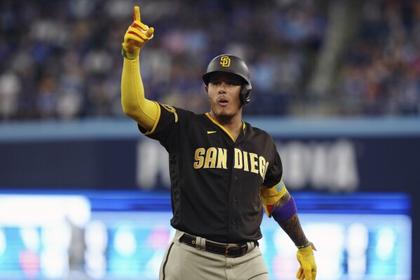 San Diego Padres' Manny Machado celebrates his two-run single against the Toronto Blue Jays during the fifth inning of a baseball game Wednesday, July 19, 2023, in Toronto. (Chris Young/The Canadian Press via AP)