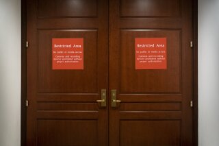 In this Nov. 6, 2019, photo, bright red signs alert non-authorized personnel at the entrance to the House SCIF, the Sensitive Compartmented Information Facility, located three levels beneath the Capitol where witnesses and lawmakers hold closed interviews in the impeachment inquiry on President Donald Trump's efforts to press Ukraine to investigate his political rivals, in Washington. (AP Photo/J. Scott Applewhite)