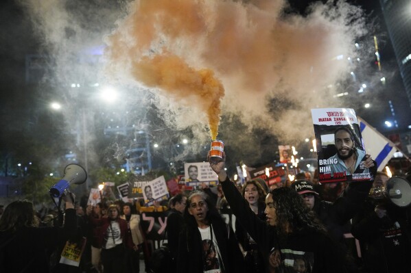 FILE - Demonstrators wave signs and shout slogans during a protest calling for the release of hostages held in the Gaza Strip by the Hamas militant group, in Tel Aviv, Israel, Saturday, Feb. 24, 2024. Israel and Hamas are inching toward a new deal that would free some of the roughly 130 hostages held in the Gaza Strip in exchange for a weeks-long pause in the war, now in its fifth month. A deal would bring some respite to desperate people in Gaza, who have borne a staggering toll in the war, as well as to the anguished families of hostages taken during Hamas' Oct. 7 attack that sparked the war. (AP Photo/Ohad Zwigenberg, File)