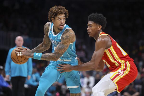 Charlotte Hornets guard Kelly Oubre Jr. (12) is defended by Atlanta Hawks forward De'Andre Hunter (12) in the first half of an NBA basketball game Sunday, Oct. 23, 2022, in Atlanta. (AP Photo/Brett Davis)