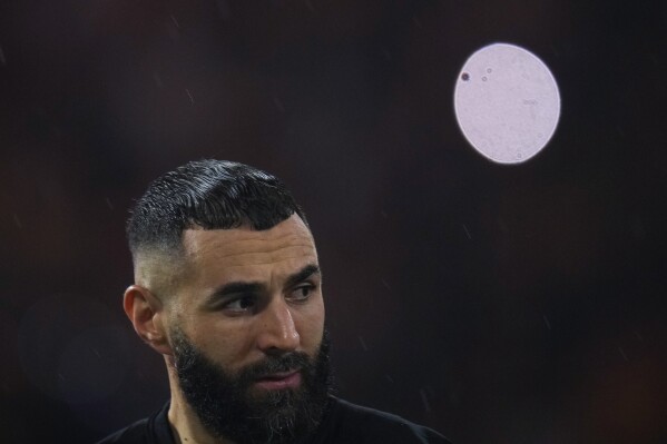FILE - Al Ittihad's Karim Benzema stands at the pitch under the rain prior the Soccer Club World Cup first round soccer match between Al Ittihad and Auckland City FC at King Abdullah Sports City stadium in Jeddah, Saudi Arabia, Tuesday, Dec. 12, 2023. Karim Benzema has filed a defamation lawsuit against France's Interior Minister Gérald Darmanin, who accused the soccer star of having links to the Muslim Brotherhood. (AP Photo/Manu Fernandez, File)