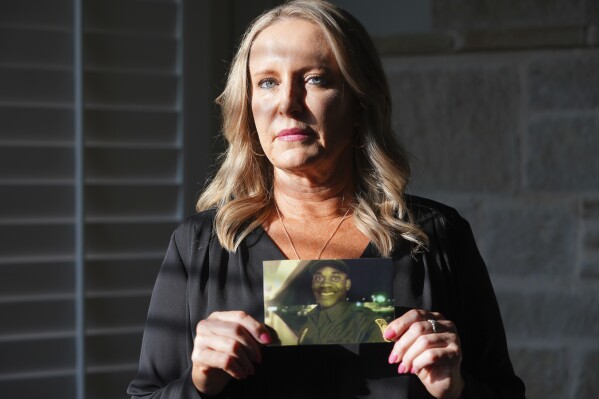 Lisa Afolayan poses with a photo of her late husband, U.S. Border Patrol agent Nate Afolayan, at her home in The Colony, Texas, May 24, 2025. (AP Photo/LM Otero)