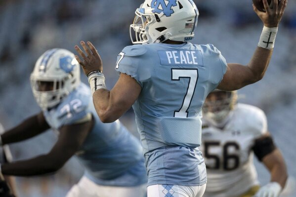 North Carolina quarterback Sam Howell (7), who has the word "Peace"  as his nameplate, throws a pass against Notre Dame during an NCAA college football game, Friday, Nov. 27, 2020, at Kenan Stadium in Chapel Hill, N.C. (Robert Willett/The News & Observer via AP)