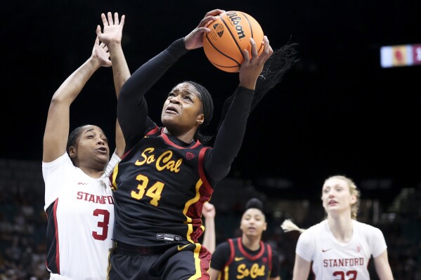 Southern California center Clarice Akunwafo (34) grabs a rebound over Stanford forward Nunu Agara (3) during the first half of an NCAA college basketball game in the championship of the Pac-12 tournament Sunday, March 10, 2024, in Las Vegas. (AP Photo/Ian Maule)