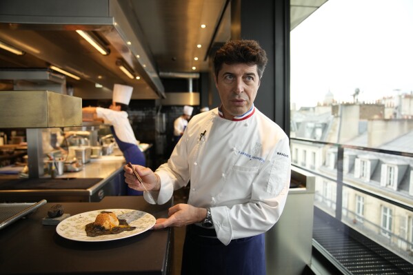 Le chef Yannick Franques prépare des plats au restaurant La Tour d'Argent à Paris, le mercredi 13 décembre 2023. (AP Photo/Christophe Ena)