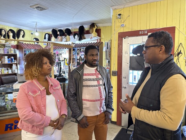 Clemene Bastien and Theslet Benoir talk with Pastor Calherbe Monel inside Bastien and Benoir's Eben-Ezer Variety Market in Parksley, Va., on WEdnesday, Jan. 24, 2024. (AP Photo/Ben Finley)