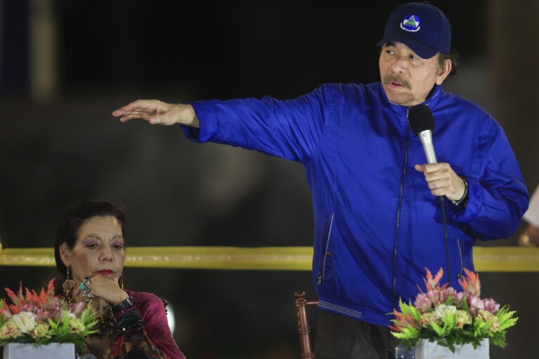 FILE - Nicaragua's President Daniel Ortega speaks during a ceremony in Managua, Nicaragua, March 21, 2019, accompanied by first lady and Vice President Rosario Murillo. Ortega and Murillo blame “terrorist” clergy for supporting the civil unrest they claim amounts to plotting a coup against them. Clergy and lay observers say the government is trying to quash the Catholic church because it remains the rare critic in Nicaragua that dares to oppose state violence and whose voice is respected by many citizens. (AP Photo/Alfredo Zuniga, File)