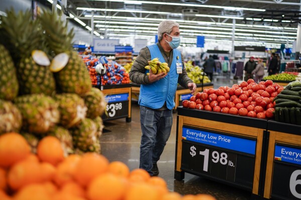 FILE - A worker carries bananas inside the Walmart Supercenter on Feb. 9, 2023, in North Bergen, New Jersey. Walmart reports earnings on Thursday, May 17, 2024. (AP Photo/Eduardo Munoz Alvarez, File)