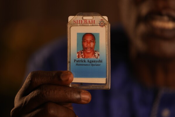 Patrick Aganyebi, a maintenance operator aboard the Trinity Spirit oil ship, holds up his ID card in his home in Igbokoda, Nigeria, on Tuesday, Sept. 6, 2022. Days after being hospitalized from the injuries they sustained escaping the fire on the Trinity Spirit, Aganyebi and his colleague Pius Orofin learned they were being sent to jail, accused of conspiring to commit “Murder, Arson, and Malicious Damage,” according to charging documents. (AP Photo/Sunday Alamba)