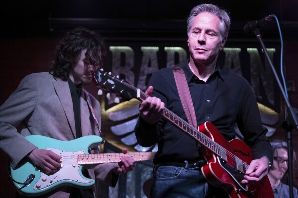 US Secretary of State Antony Blinken performs "Rockin' in the Free World" with members of The 1999 band at the Barman Dictat bar in Kyiv, Tuesday, May 14, 2024. Blinken sought Tuesday to rally the spirits of glum Ukrainians facing a fierce new Russian offensive, assuring them that they are not alone and that billions of dollars in American military aid on its way to the country would make a “real difference” on the battlefield. (Brendan Smialowski/Pool photo via Ǻ)