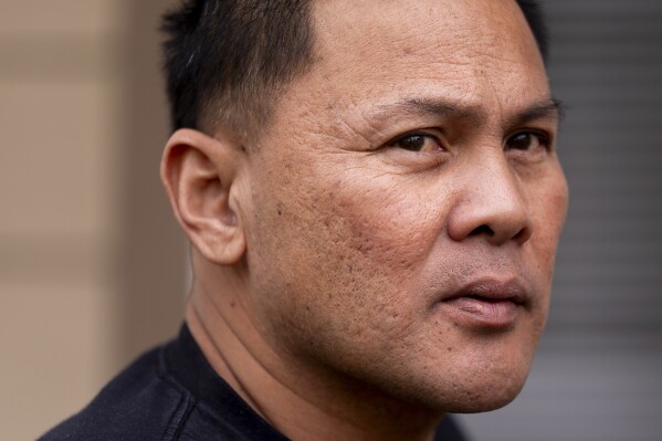 Seafarer Reyner Dagalea looks out from the porch of a temporary rental house in Lacey, Wash., on Tuesday, Jan. 30, 2024. (AP Photo/Lindsey Wasson)