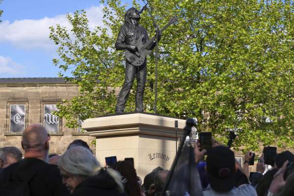 Motorhead fans take pictures of a statue to commemorate Lemmy Kilmister the Motorhead frontman in Burslem, Stoke on Trent, England, Friday, May 9, 2025. The musician, once described as having 'one of the most recognizable voices in rock', was born in Burslem and a statue has been crafted by acclaimed local sculptor and lifelong Motorhead fan Andy Edwards. (AP Photo/Kirsty Wigglesworth)