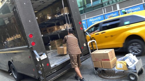 FILE - A United Parcel Service driver loads his truck, adjacent to a UPS Store, in New York, Thursday, May 11, 2023. Frustrated by what he called an 
