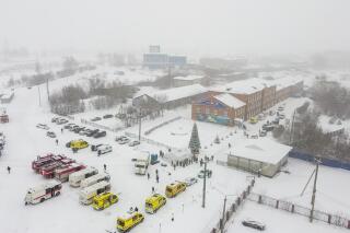 Ambulances and fire trucks are parked near the Listvyazhnaya coal mine out of the Siberian city of Kemerovo, about 3,000 kilometres (1,900 miles) east of Moscow, Russia, Thursday, Nov. 25, 2021. A fire at a coal mine in Russia's Siberia killed 11 people and injured more than 40 others on Thursday, with dozens of others still trapped, authorities said. (Governor of Kemerovo region press office photo via AP)