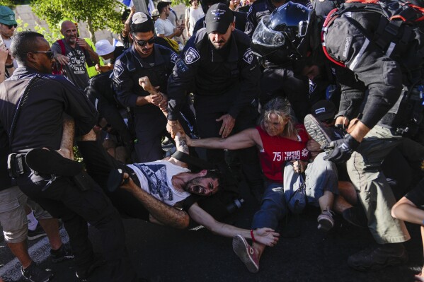 Israeli police disperse demonstrators blocking a road during a protest against plans by Prime Minister Benjamin Netanyahu's government to overhaul the judicial system, in Jerusalem, Monday, July 24, 2023. Israeli lawmakers on Monday approved a key portion of Prime Minister Benjamin Netanyahu's divisive plan to reshape the country's justice system despite massive protests that have exposed unprecedented fissures in Israeli society. (AP Photo/Ohad Zwigenberg)