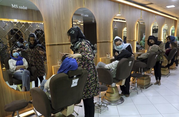 FILE- Beauticians put makeup on customers at Ms. Sadat's Beauty Salon in Kabul, Afghanistan, Sunday, April 25, 2021. A spokesman at Afghanistan's Vice and Virtue Ministry said Tuesday, July 4, 2023, the Taliban are banning women's beauty salons. (AP Photo/Rahmat Gul, File)