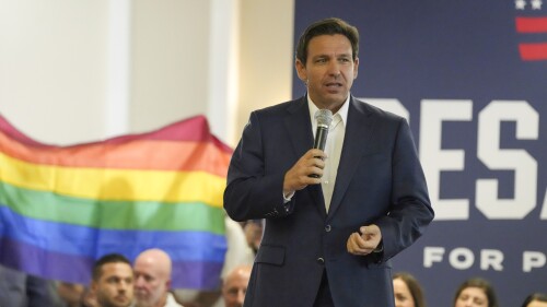 Protesters unfold and raise a rainbow flag behind Republican presidential candidate Florida Gov. Ron DeSantis as he speaking during a campaign event on Monday, July 17, 2023, in Tega Cay, S.C. (AP Photo/Meg Kinnard)