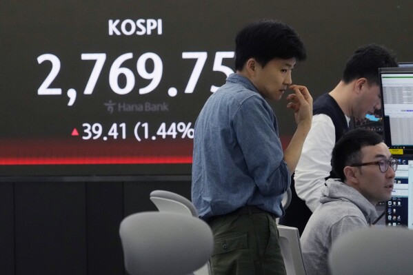 2024年5月16日，星期四，韩国首尔，韩国央行韩亚银行总部的外汇交易室，外汇交易员在显示韩国综合股价指数（KOSPI）的屏幕附近工作。（美联社照片/Ahn Young-joon）
