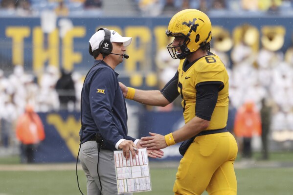 West Virginia head coach Neal Brown and quarterback Nicco Marchiol during the first half of an NCAA college football game, Saturday, Sept. 23, 2023, in Morgantown, W.Va. West Virginian won 20-13. (AP Photo/Chris Jackson)