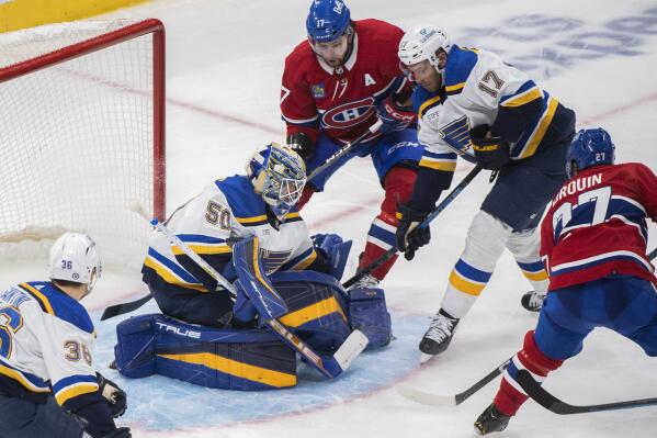 Montreal Canadiens' Jonathan Drouin (27) scores against St. Louis Blues goaltender Jordan Binnington (50) as Blues' Josh Leivo, second from right, and Canadiens' Josh Anderson, top left, look for a rebound during third-period NHL hockey game action in Montreal, Saturday, Jan. 7, 2023. (Graham Hughes/The Canadian Press via AP)