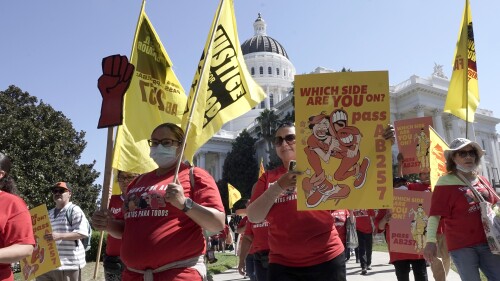 FILE - Fast food workers and their supporters march past the California state Capitol in Sacramento, Tuesday, Aug. 16, 2022. California Gov. Gavin Newsom and legislative leaders have agreed to restore funding to the Industrial Welfare Commission, which has the power to regulate wages, hours and working conditions in California. Business groups oppose restoring the commission. A law that would create a similar commission to regulate the fast food industry passed last year but has been put on hold pending the outcome of a 2024 referendum. (AP Photo/Rich Pedroncelli, File)