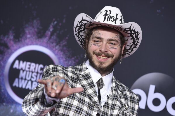 FILE - In this Nov. 24, 2019, file photo Post Malone arrives at the American Music Awards at the Microsoft Theater in Los Angeles. The rap-pop star will perform at “Dick Clark’s New Year’s Rockin’ Eve with Ryan Seacrest 2020” in New York City on Dec. 31, Dick Clark Productions announced Tuesday, Dec. 17. (Photo by Jordan Strauss/Invision/AP, File)