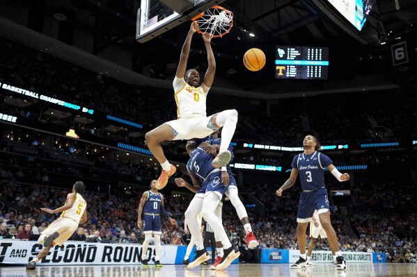 Tennessee forward Jonas Aidoo dunks over Saint Peter's guard Armoni Zeigler during the first half of a first-round college basketball game in the NCAA Tournament, Thursday, March 21, 2024, in Charlotte, N.C. (AP Photo/Chris Carlson)