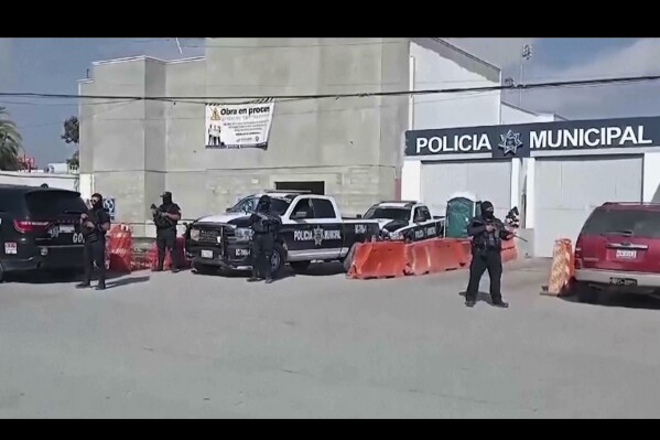 In this image made from video, Mexico's police officers stand guard at the Ensenada station in Ensenada, Mexico, Thursday, May 2, 2024. Mexican authorities said Thursday they have found tents and questioned a few people in the case of two Australians and an American who went missing over the weekend in the Pacific coast state of Baja California. (Ǻ Photo)