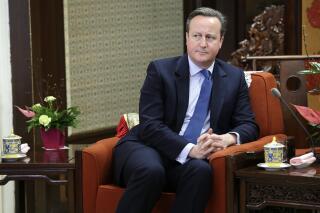 FILE - In this Tuesday, Nov. 27, 2018 file photo, former British Prime Minister David Cameron meets China's Premier Li Keqiang at Zhongnanhai leadership compound, in Beijing, China. Cameron says he never suspected that a financial services company that he lobbied for would go under, threatening thousands of jobs at a steel firm it helped finance. Cameron was summoned Thursday, May 13, 2021 to answer lawmakers’ questions about his efforts to win government funds for Greensill Capital, which collapsed in March(Jason Lee/Pool Photo via AP, file)