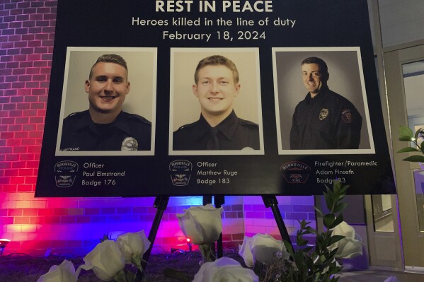 Photos of Burnsville police officers, from left, Paul Elmstrand, Matthew Ruge and firefighter/paramedic Adam Finseth are displayed during a community vigil, Tuesday, Feb. 20, 2024 in Burnsville, Minn. Members of the community gathered to honor the three first responders, who were killed in the line of duty while responding to a domestic situation Sunday, Feb. 18. A fourth police officer, also shot by the suspect, was wounded and is recovering. (Mara H. Gottfried/Pioneer Press via AP)