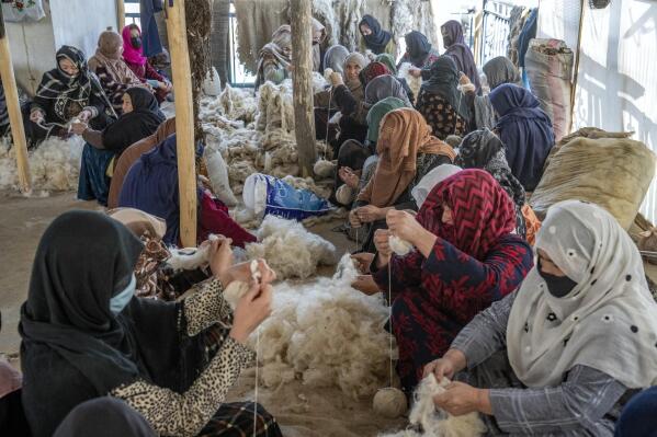 Afghan women weave wools for making carpets at a traditional carpet factory in Kabul, Afghanistan, Monday, March 6, 2023. After the Taliban came to power in Afghanistan, women have been deprived of many of their basic rights. (AP Photo/Ebrahim Noroozi)