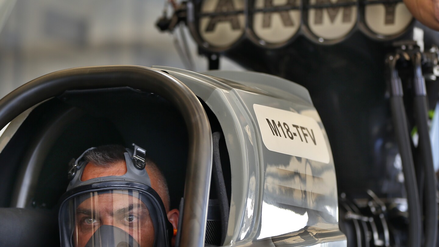 FILE - Tony Schumacher stares out from the seat of his Top Fule dragster while his crew runs tests prior to his first qualifying run of the Menards NH