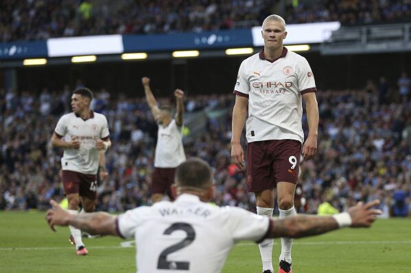 Manchester City's Erling Haaland celebrates scoring their side's second goal of the game with team-mate Kyle Walker during the Premier League soccer match between Manchester City and Burnley FC at Turf Moor, Burnley, England, Friday Aug. 11, 2023. (Nigel French/PA via AP)