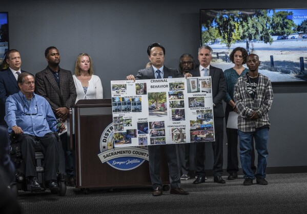 Sacramento County District Attorney Thien Ho holds a poster collage titled "criminal behavior" as he announces on Tuesday, Sept. 19, 2023, that his office is suing the city of Sacramento for creating a public nuisance by failing to take stronger action on homeless camps. A Sacramento prosecutor is suing California's capital city over failure to clean up homeless encampments. Sacramento District Attorney Thien Ho says his office asked the city to enforce laws around sidewalk obstruction and to create additional professionally operated camping sites. (Hector Amezcua/The Sacramento Bee via AP)