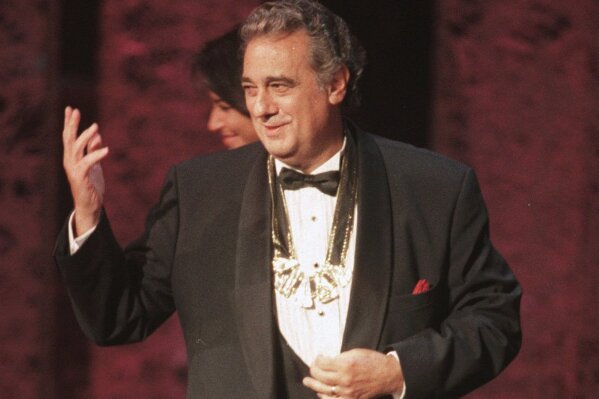 FILE - In this Tuesday, Sept. 14, 1999 file photo, Placido Domingo acknowledges the audience after receiving the 1999 Hispanic Heritage Award at the John F. Kennedy Center for the Performing Arts in Washington. An evening before a performance of “Le Cid,” part of the Washington Opera’s 1999-2000 season, opera singer Angela Turner Wilson said she and Domingo were having their makeup done together when he rose from his chair, stood behind her and put his hands on her shoulders. As she looked at him in the mirror, he suddenly slipped his hands under her bra straps, she said, then reached down into her robe and grabbed her bare breast. "It hurt," she told The Associated Press. “It was not gentle. He groped me hard.” She said Domingo then turned and walked away, leaving her stunned and humiliated. (AP Photo/Leslie Kossoff)