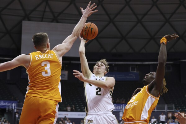 Purdue guard Fletcher Loyer (2) shoots between Tennessee guard Dalton Knecht (3) and guard Jahmai Mashack during the first half of an NCAA college basketball game Tuesday, Nov. 21, 2023, in Honolulu. (AP Photo/Marco Garcia)