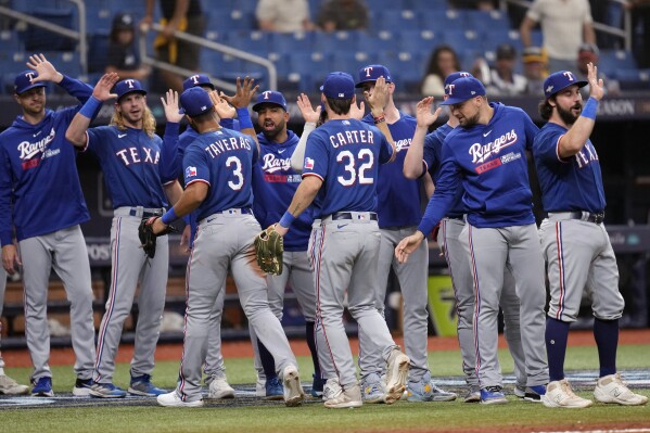 Texas Rangers players celebrate after defeating the Tampa Bay Rays in Game 1 of an AL wild-card baseball playoff series Tuesday, Oct. 3, 2023, in St. Petersburg, Fla. (AP Photo/John Raoux)