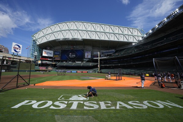 Sixto Zapata paints a postseason logo on the field at Minute Maid Park during an ALDS baseball workout Friday, Oct. 6, 2023, in Houston. The Houston Astros will host the Minnesota Twins in Game 1 of an ALDS series Saturday. (AP Photo/David J. Phillip)
