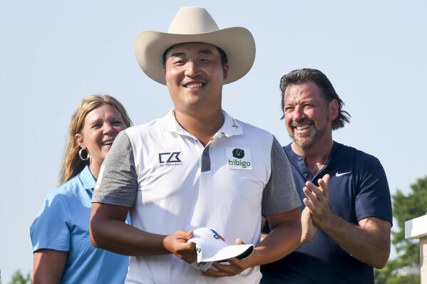 K.H. Lee, of South Korea, smiles after his was given a custom-made cowboy hat after winning the AT&T Byron Nelson golf tournament in McKinney, Texas, on Sunday, May 15, 2022. (AP Photo/Emil Lippe)